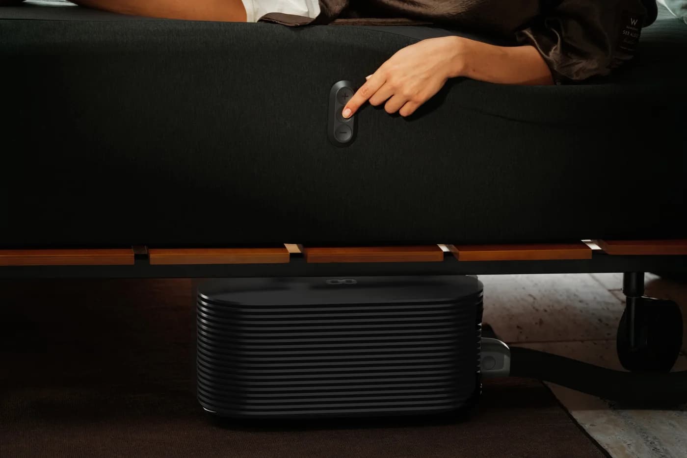 A hand using the physical temperature controls on the edge of a Pod 6 Cover